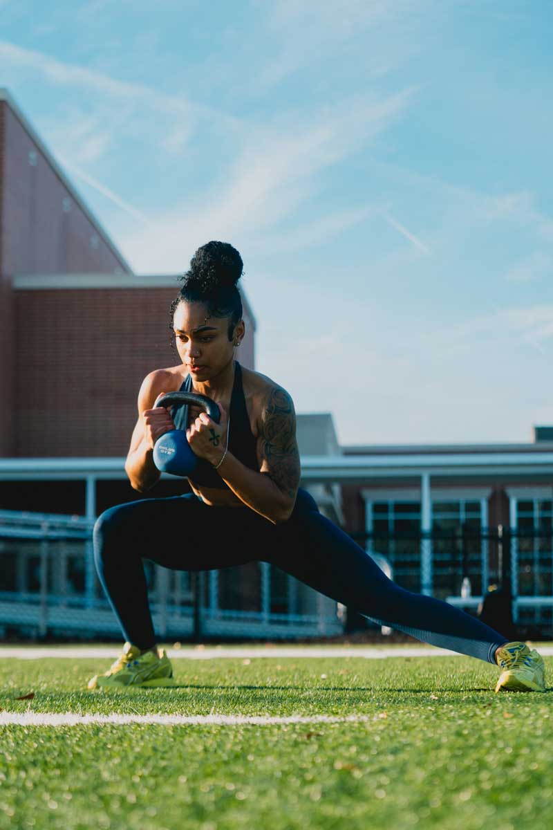 The coach is holding the kettlebell.