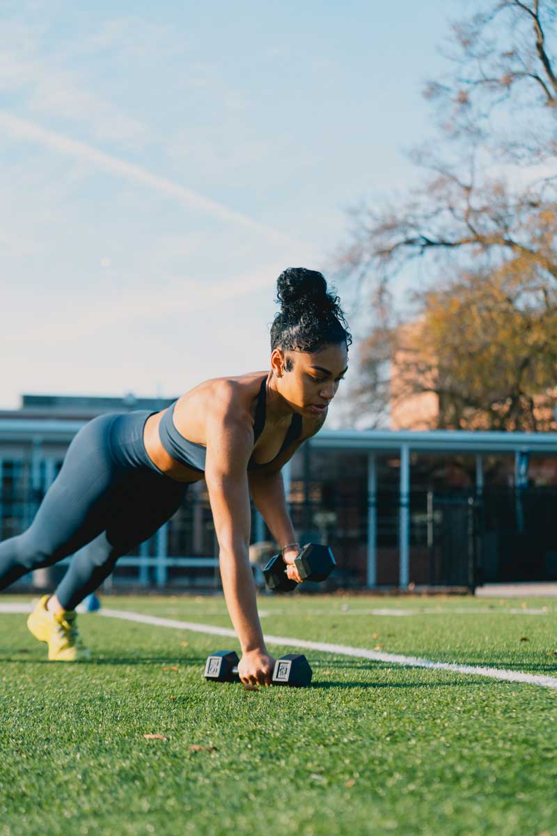 The coach is excercising with the dumbbells.